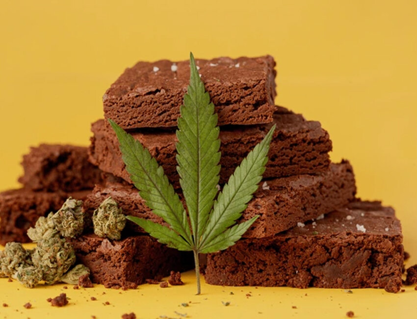 Brownies com folha de cannabis em fundo amarelo