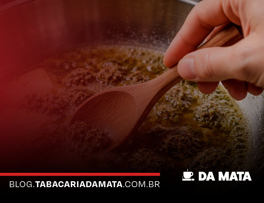 Pessoa mexendo molho em panela de aço inox.