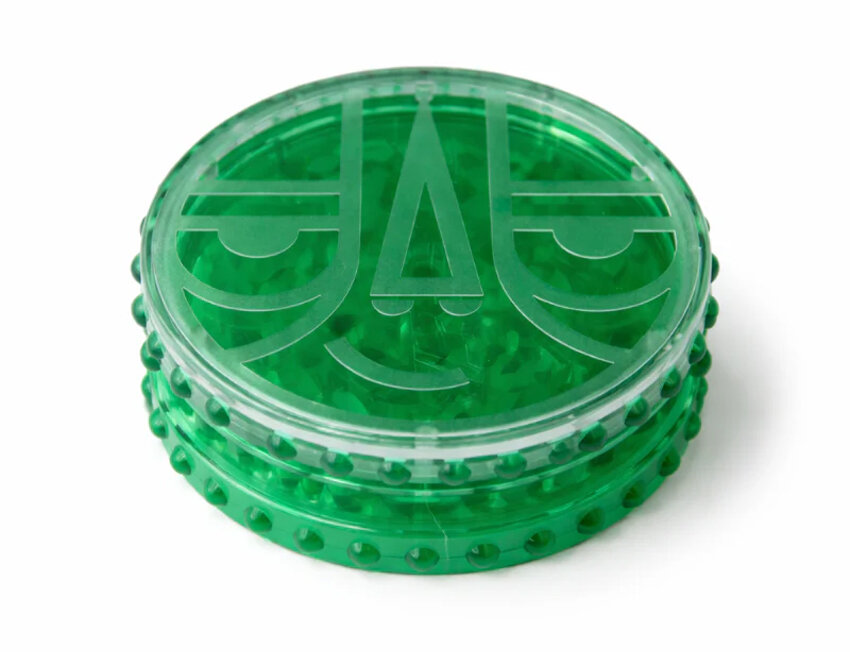 Moedor de ervas transparente verde com padrão facial