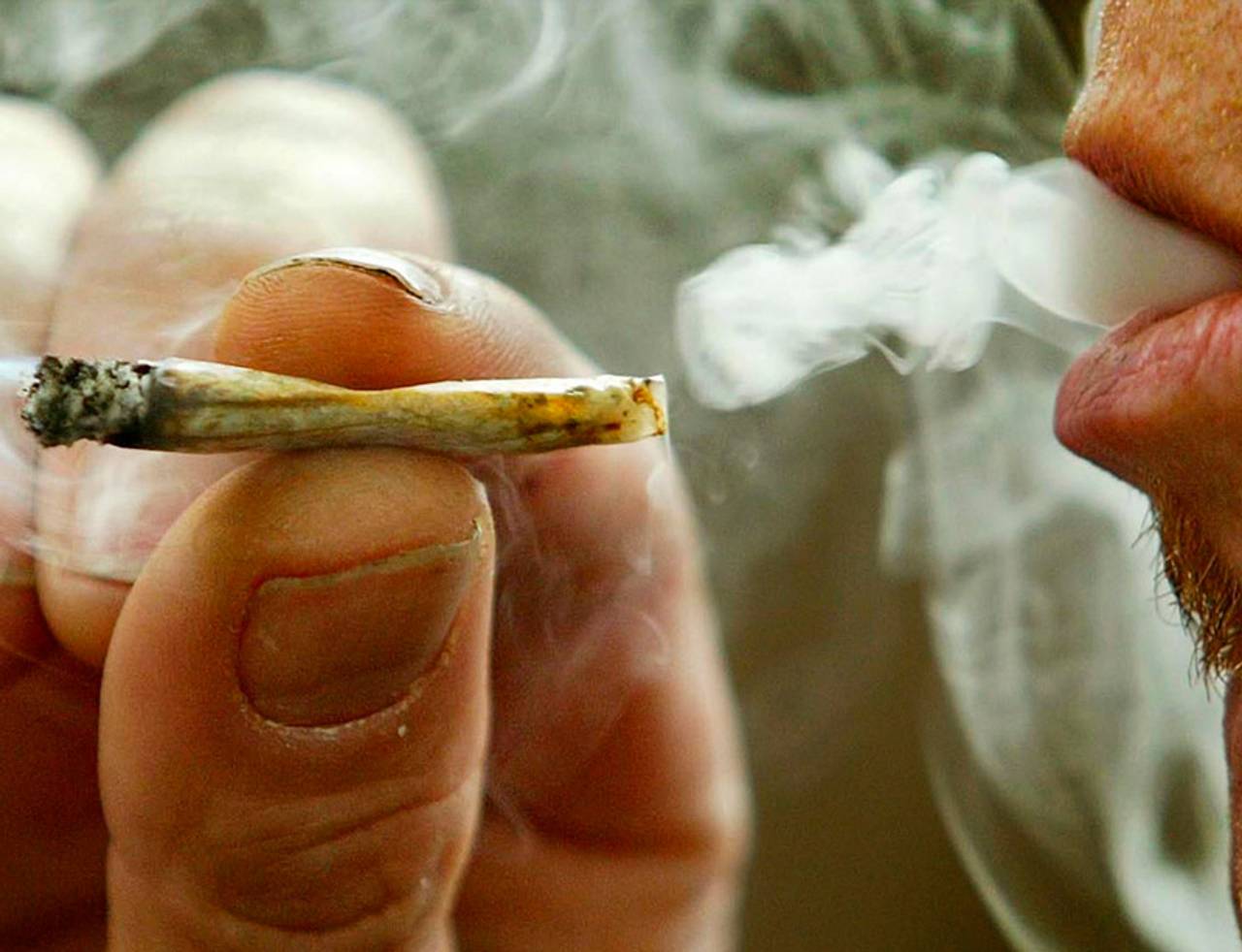 homem fumando finim bolado com AK 47 straim