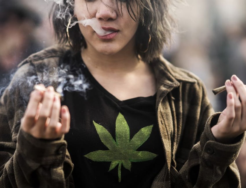 pessoa com camiseta com estampa de erva segura dois cigarros enrolados com blunts terpenados