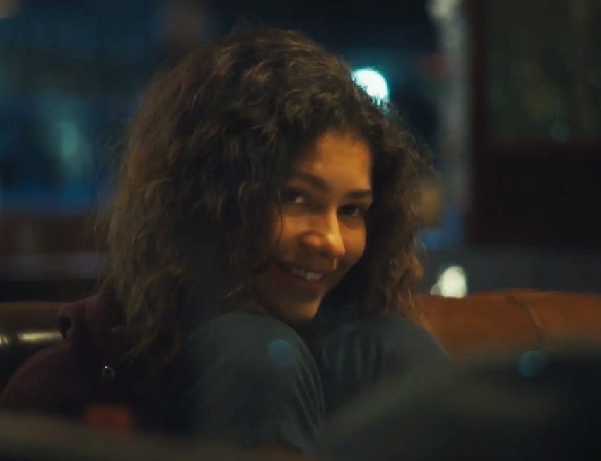 imagem de uma menina com o cabelo cacheado, sorrindo e olhar de chapada