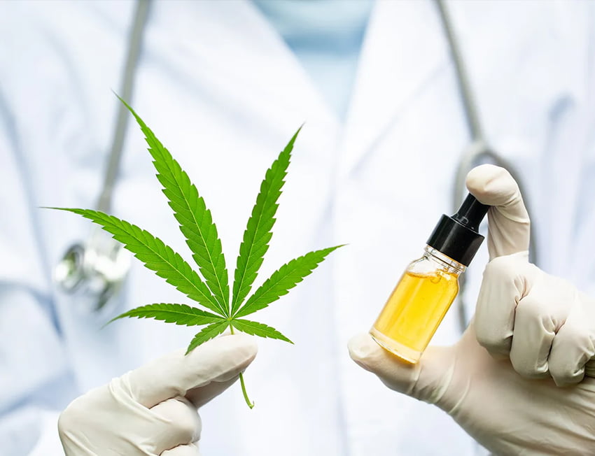 pessoa de jaleco segurando uma folha de maconha e um óleo cbd