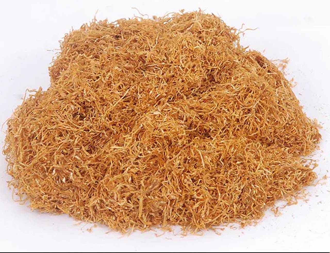 foto em close de um punhado de tabaco triturado sobre uma mesa branca