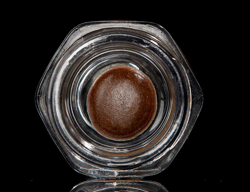 Frasco de vidro com esfera marrom em seu interior