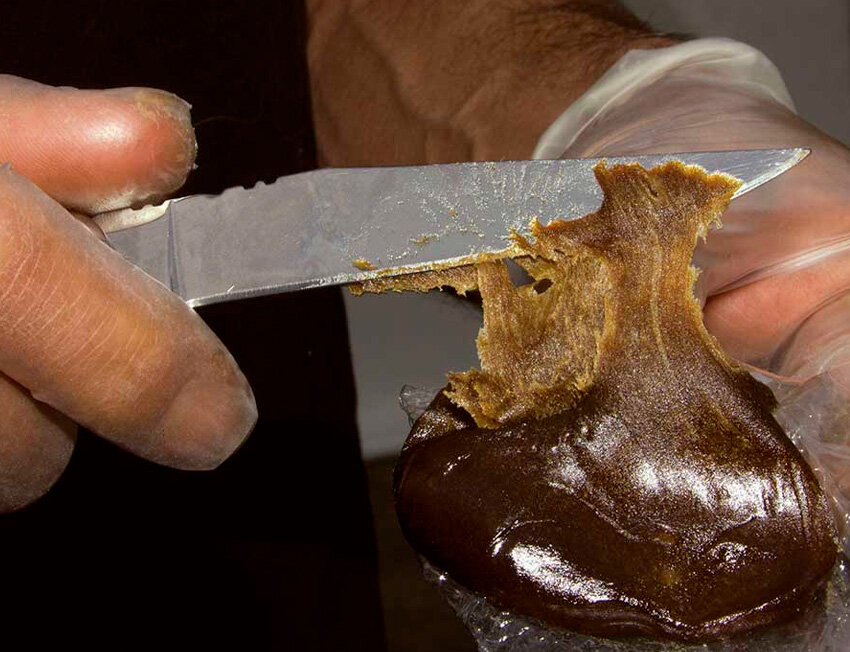 Pessoa cortando substância viscosa com faca